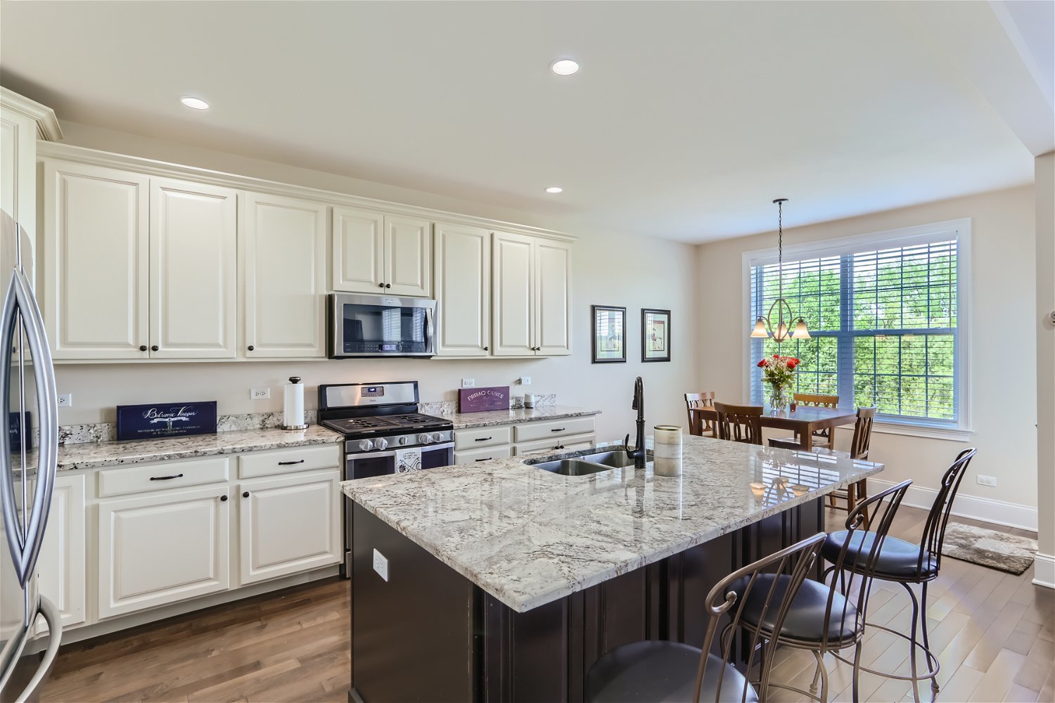 1239 Falcon Ridge Drive Elgin, IL 60124 - Photo 9 of 28 a kitchen with granite countertop white cabinets sink and stainless steel appliances