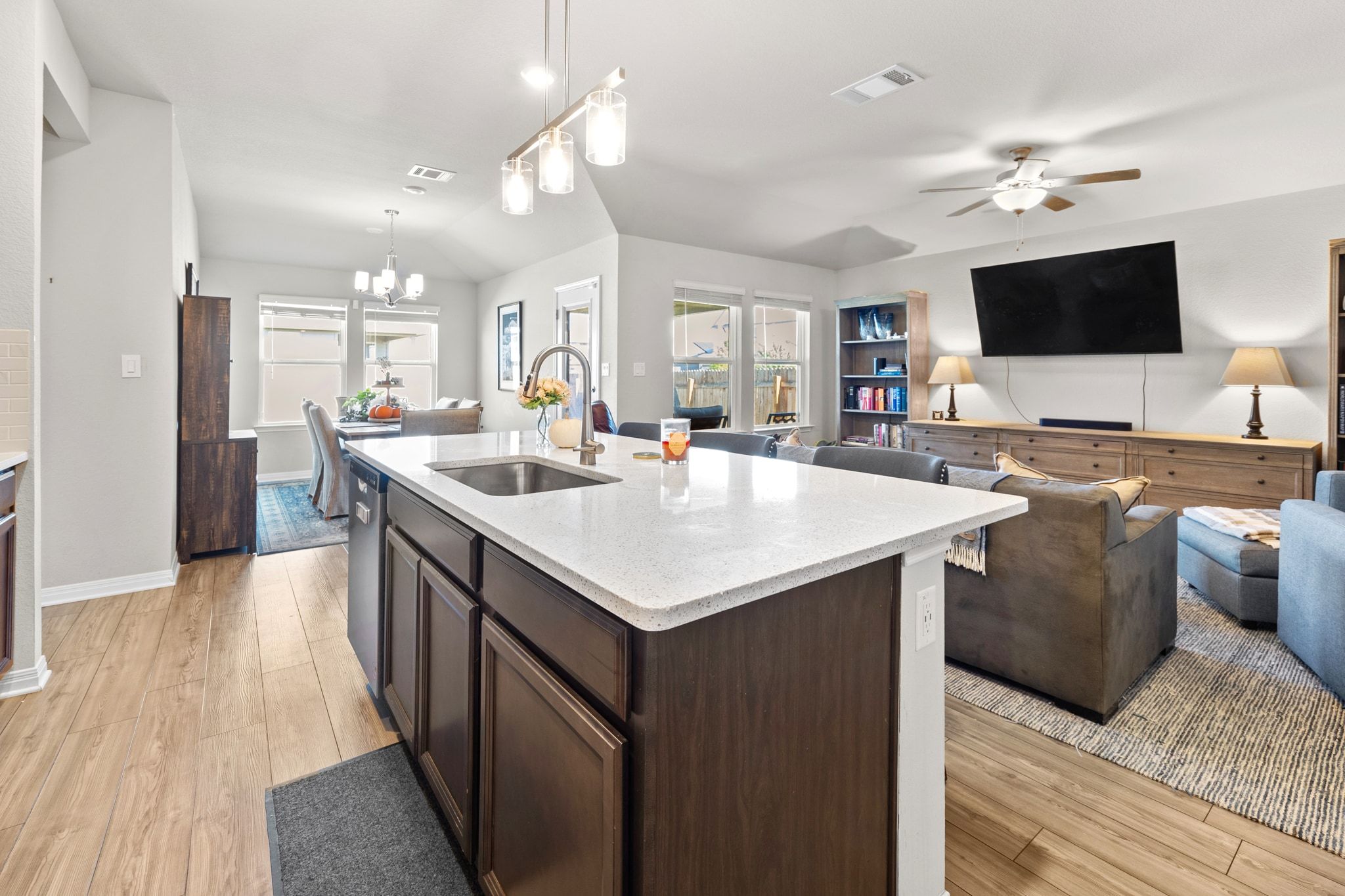 2856 Moyer Lane Round Rock, TX 78665 - Photo 26 of 27 Kitchen featuring dark brown cabinetry, light wood finished floors, open floor plan, and light stone counters