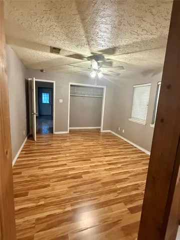 a bathroom with a wooden floor and a toilet