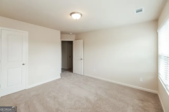 an empty room with windows and closet
