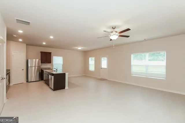 a view of a livingroom with a ceiling fan and window