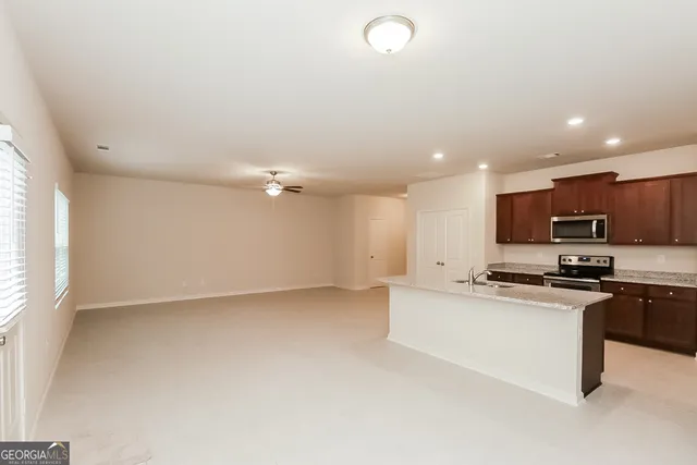 a kitchen with stainless steel appliances granite countertop a stove a sink and a microwave