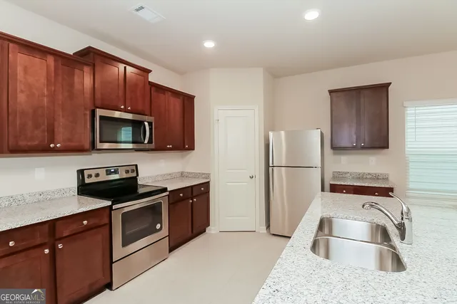 a kitchen with stainless steel appliances granite countertop a sink stove and microwave