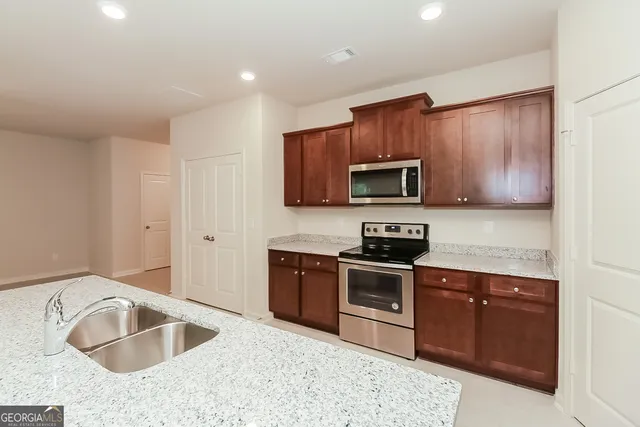 a kitchen with a sink refrigerator and microwave