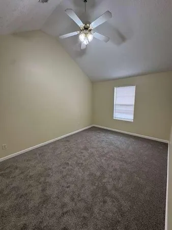 an empty room with a window and a ceiling fan