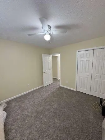 an empty room with a ceiling fan and a window