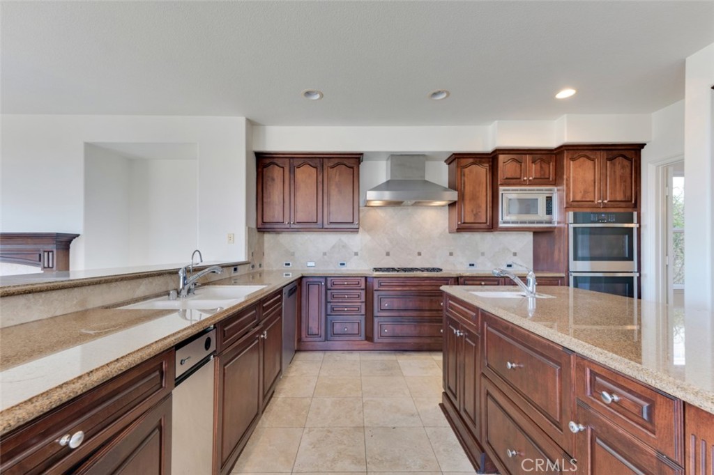 20212 Vía Medici Porter Ranch, CA 91326 - Photo 15 of 61 a kitchen with stainless steel appliances granite countertop a sink stove and cabinets
