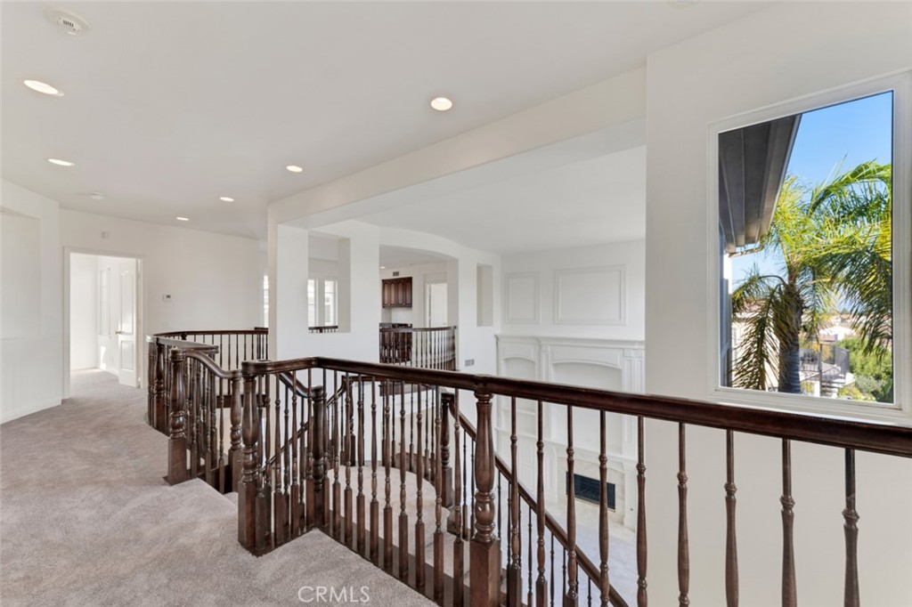 20212 Vía Medici Porter Ranch, CA 91326 - Photo 27 of 61 a view of a hallway with wooden floor and a potted plant