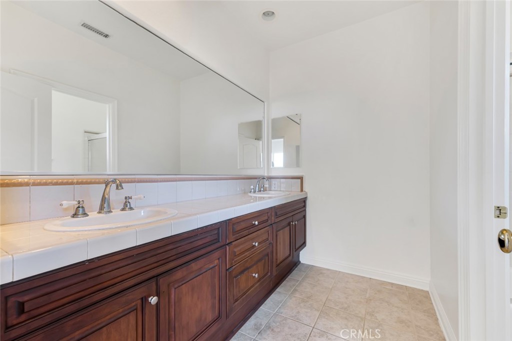 20212 Vía Medici Porter Ranch, CA 91326 - Photo 48 of 61 a bathroom with a double vanity sink and a mirror