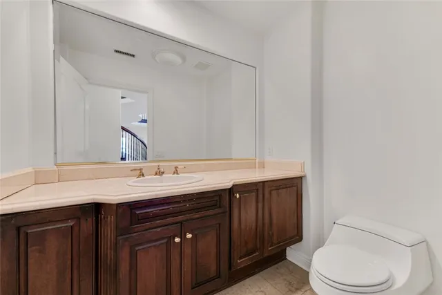 a bathroom with a granite countertop sink and a toilet