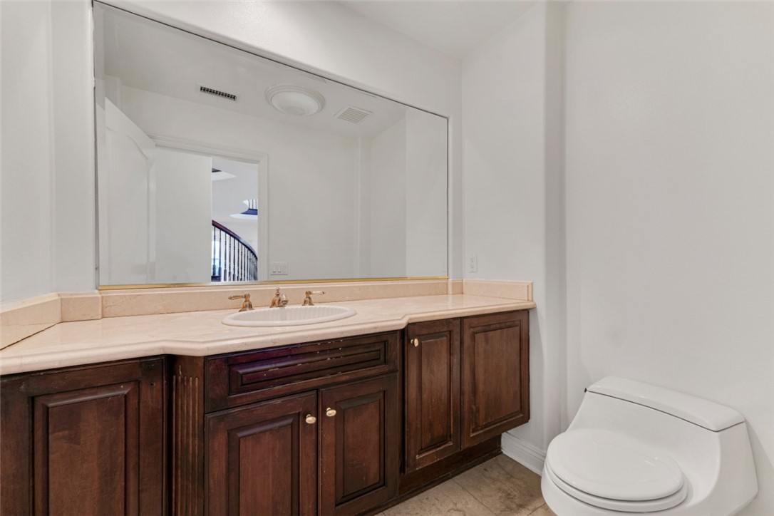 20212 Vía Medici Porter Ranch, CA 91326 - Photo 7 of 61 a bathroom with a granite countertop sink and a toilet