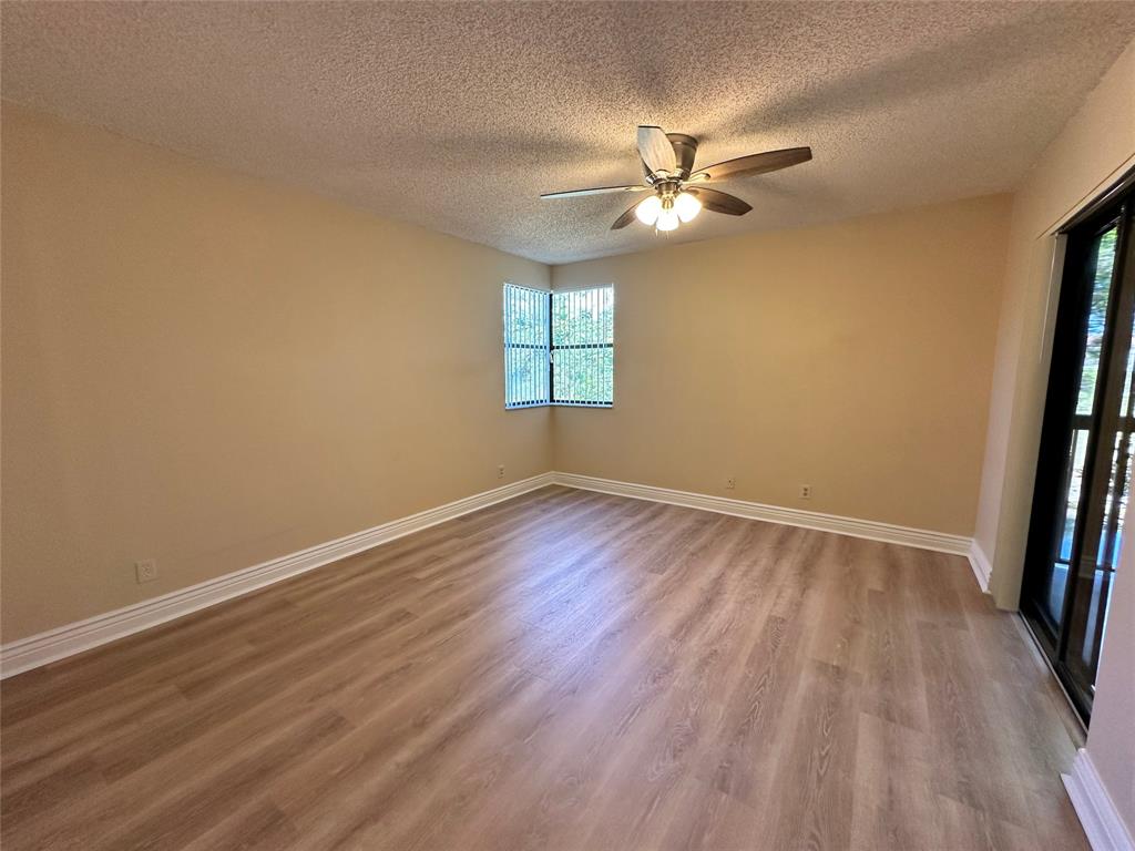 5661 Riverside Drive, Unit 202 Coral Springs, FL 33067 - Photo 14 of 25 wooden floor in an empty room with a window