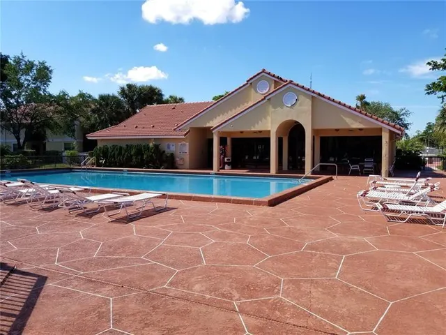 a view of a house with backyard and trees