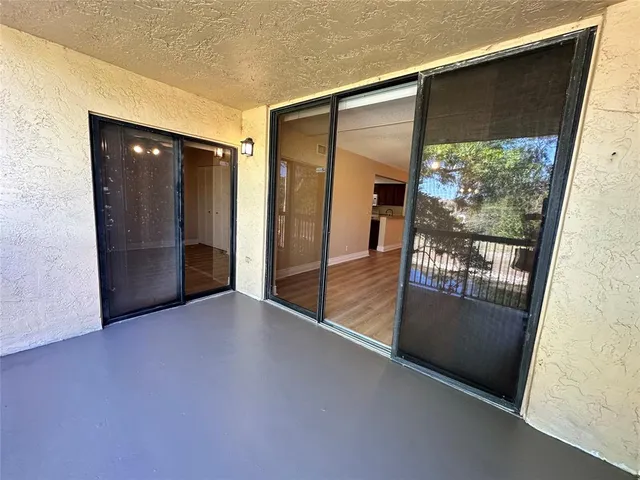 an empty room with large window and front door