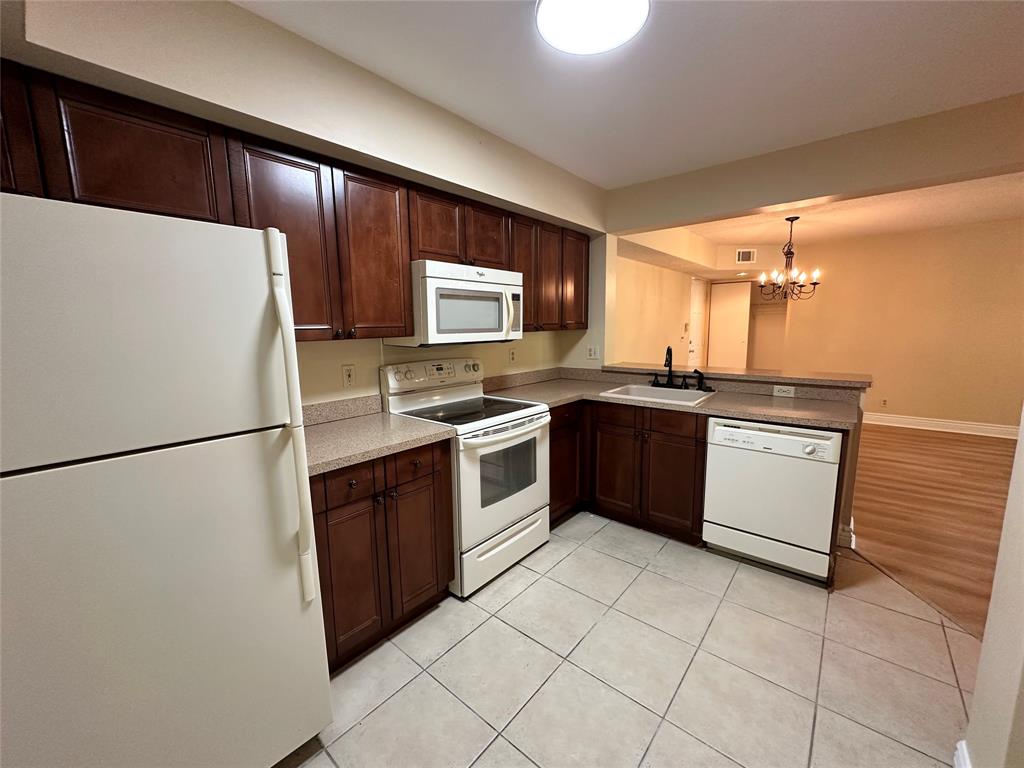 5661 Riverside Drive, Unit 202 Coral Springs, FL 33067 - Photo 10 of 25 a kitchen with stainless steel appliances a stove a sink and a refrigerator