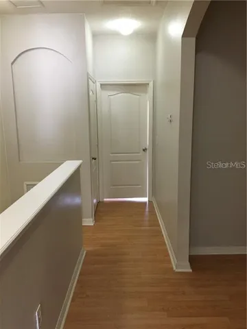 a view of hallway with wooden floor