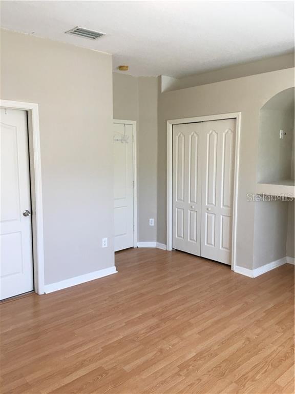 3426 High Hampton Circle Tampa, FL 33610 - Photo 14 of 27 a view of an empty room with wooden floor and closet
