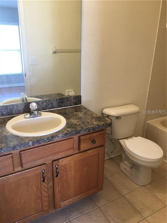 3426 High Hampton Circle Tampa, FL 33610 - Photo 17 of 27 a bathroom with a granite countertop toilet sink and mirror