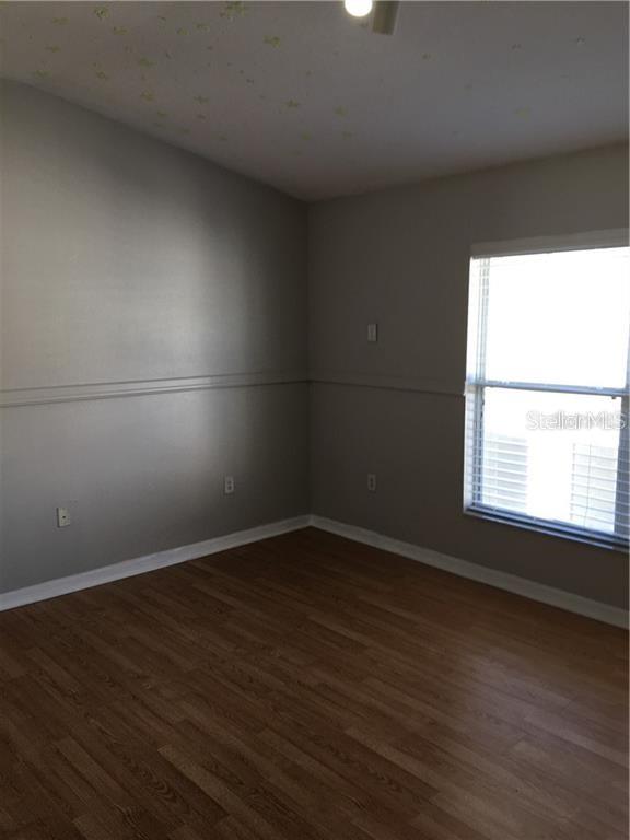 3426 High Hampton Circle Tampa, FL 33610 - Photo 19 of 27 an empty room with wooden floor and windows