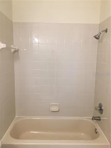 a white toilet sitting next to a shower