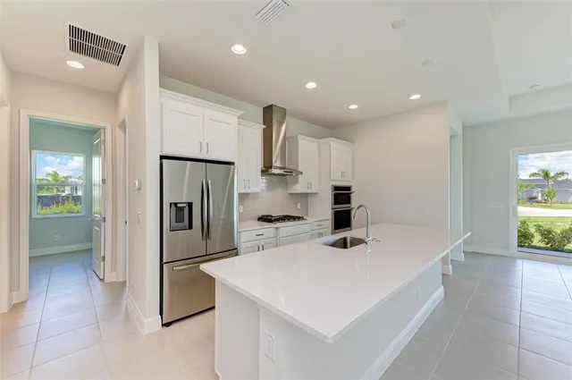 a kitchen that has a sink a refrigerator and a stove top oven