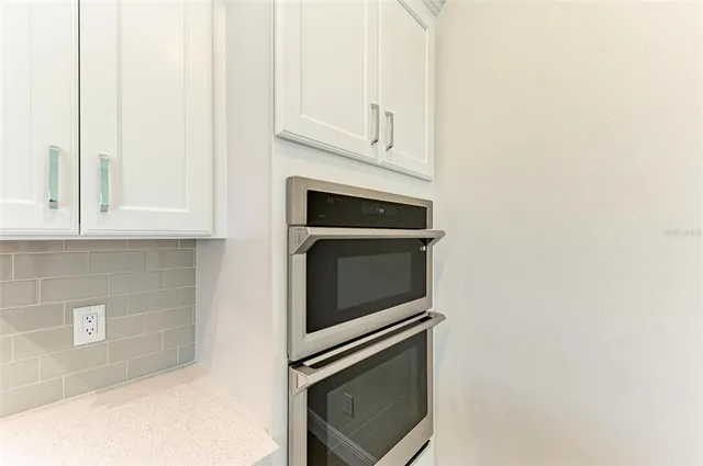 a kitchen with granite countertop white cabinets and stainless steel appliances