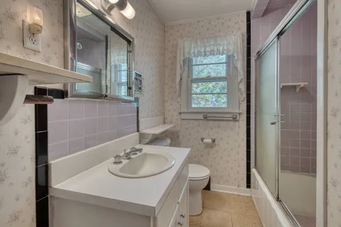 a bathroom with a sink a toilet and shower