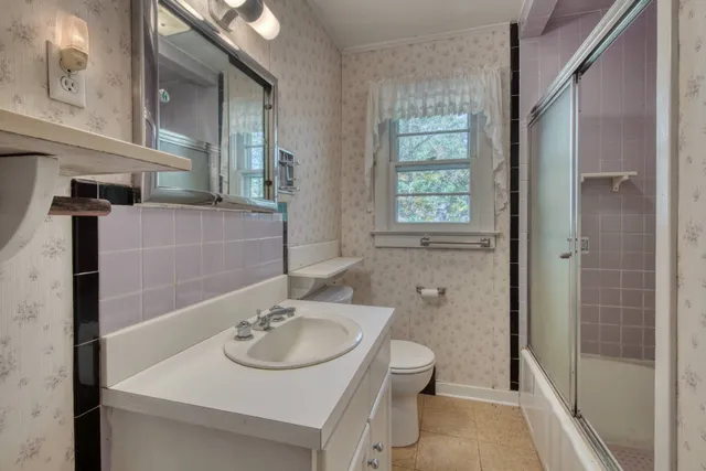 a bathroom with a sink a toilet and shower