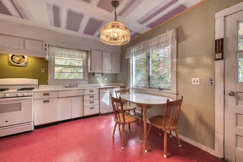 a kitchen with stainless steel appliances granite countertop a stove a refrigerator a oven a dining table and chairs with wooden floor