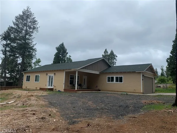a view of a house with a backyard and garage