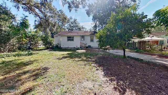 a view of a house with a yard and trees