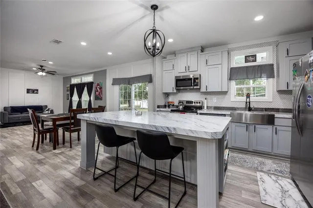 a kitchen with stainless steel appliances granite countertop a stove sink and refrigerator