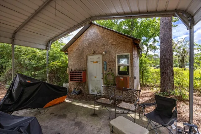 an aerial view of residential house with outdoor space and trees all around