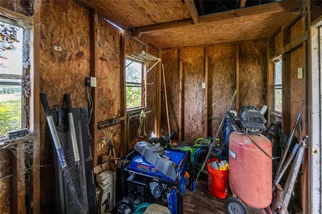 an aerial view of residential house with outdoor space and trees all around