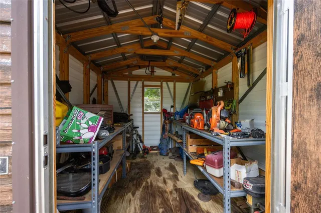 an aerial view of residential house with outdoor space and trees all around
