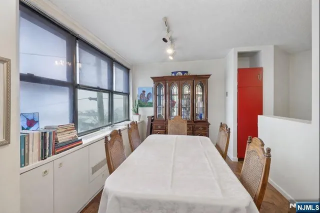 a kitchen with stainless steel appliances a stove a refrigerator a sink dishwasher with a dining table and chairs