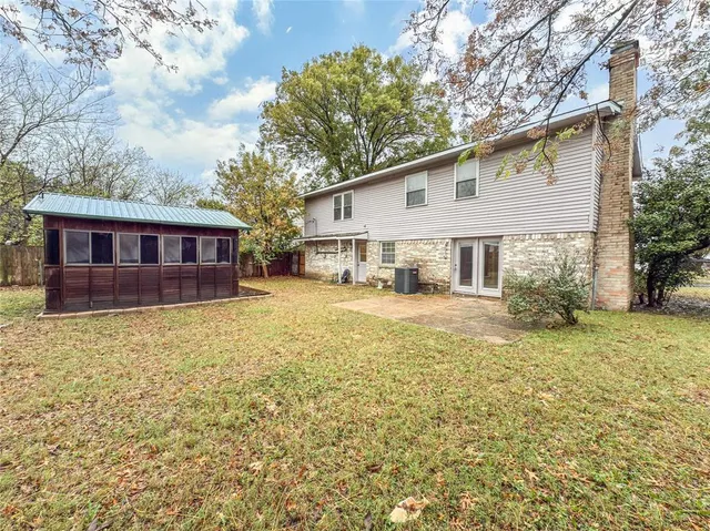 a view of a house with a yard and large tree