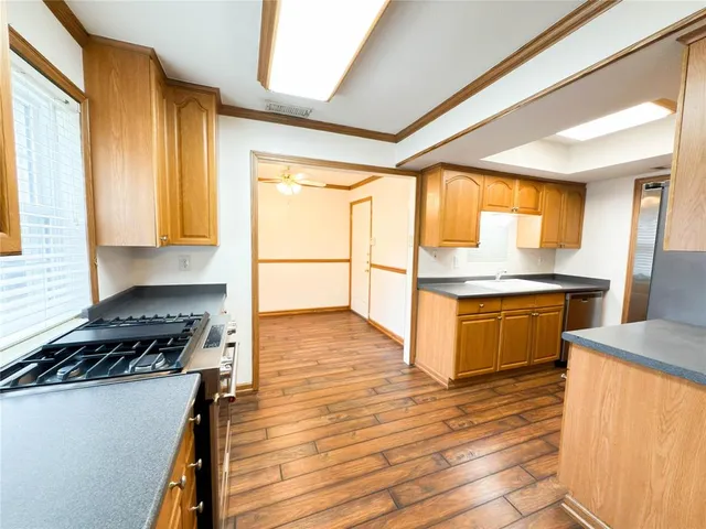 a kitchen with granite countertop a stove a sink and a refrigerator