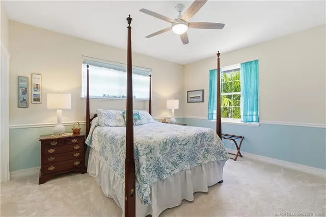 a bedroom with a bed chandelier and a window