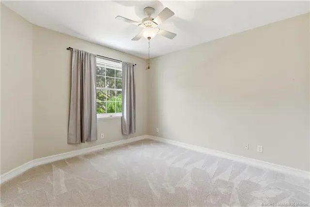 a view of a room with a window and a ceiling fan
