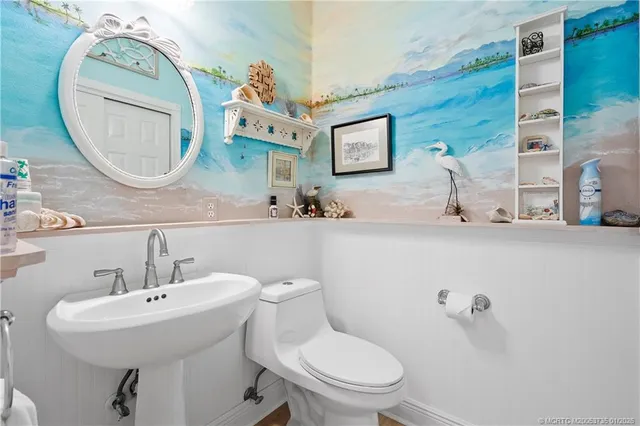 a bathroom with a toilet a sink and mirror