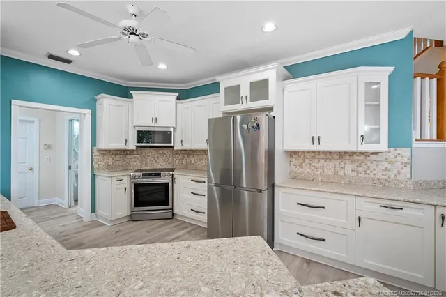 a kitchen with granite countertop a refrigerator and a stove top oven
