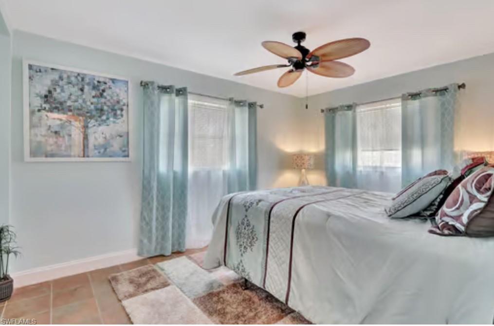 116 Capri Boulevard Naples, FL 34113 - Photo 20 of 29 Bedroom with tile patterned flooring, multiple windows, a ceiling fan, and baseboards