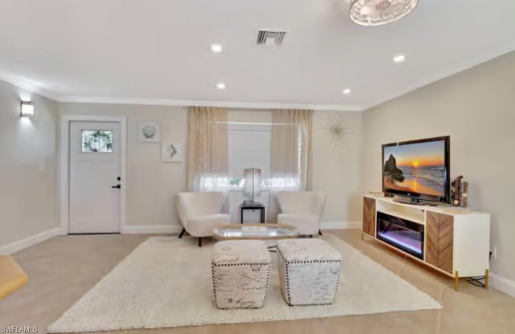 116 Capri Boulevard Naples, FL 34113 - Photo 23 of 29 Living room with visible vents, baseboards, light colored carpet, ornamental molding, and recessed lighting
