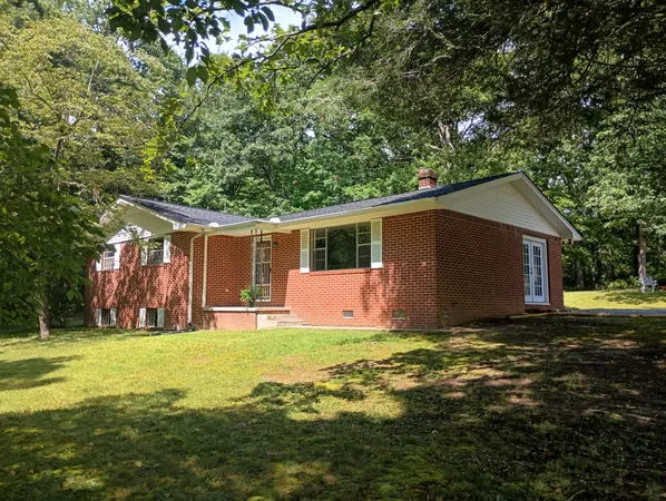 a view of a house with backyard and tree