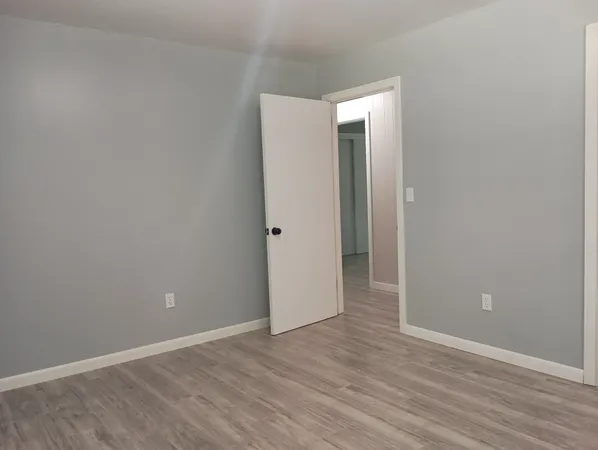 an empty room with wooden floor and closet