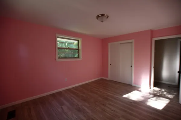 a view of an empty room with wooden floor