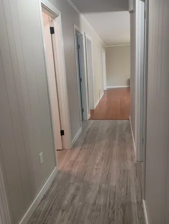 an empty room with wooden floor and a sink