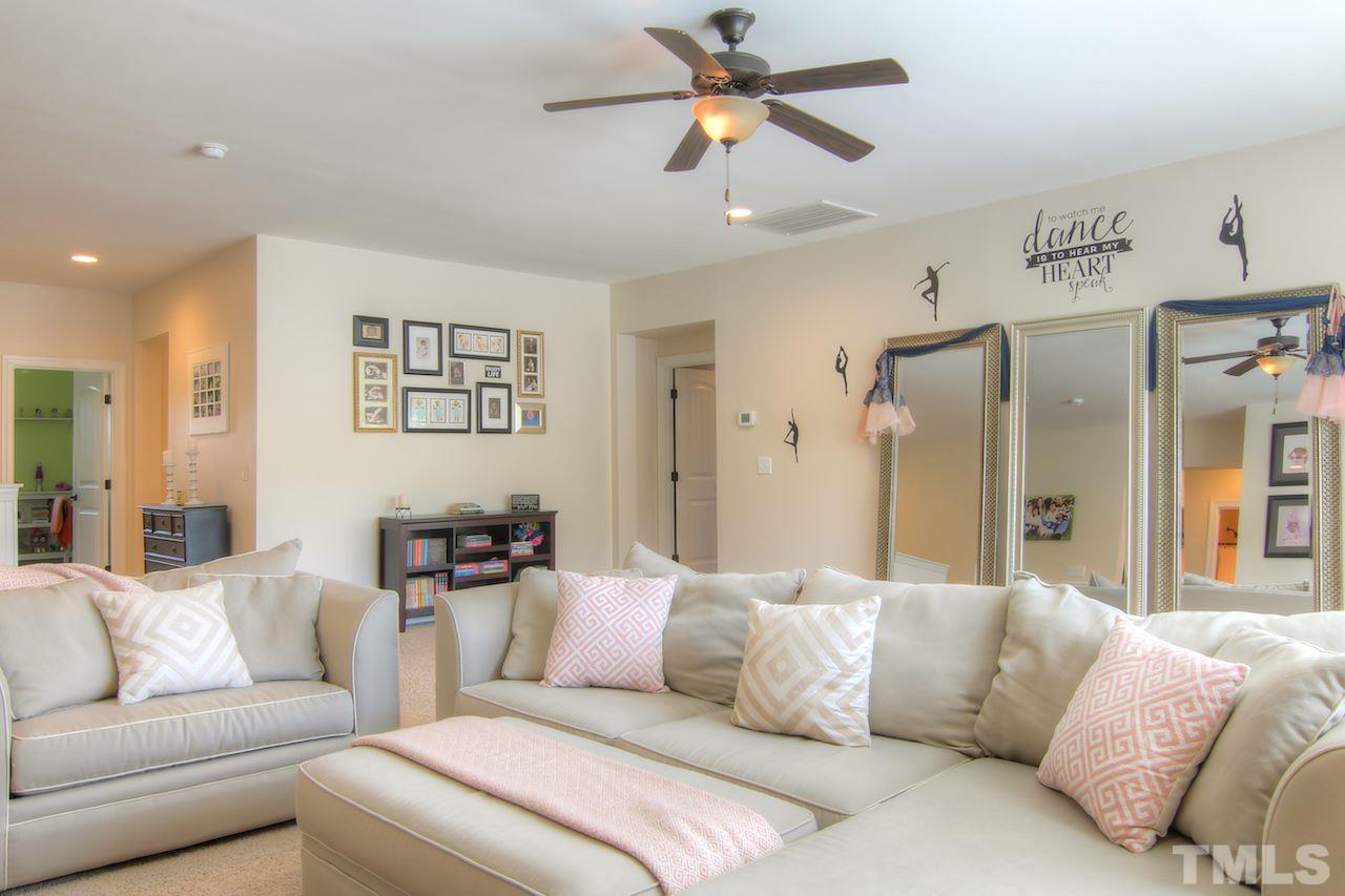 8333 Henderson Road Apex, NC 27539 - Photo 14 of 25 a living room with furniture and a chandelier