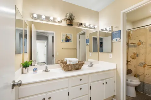 a bathroom with a double vanity sink toilet and shower
